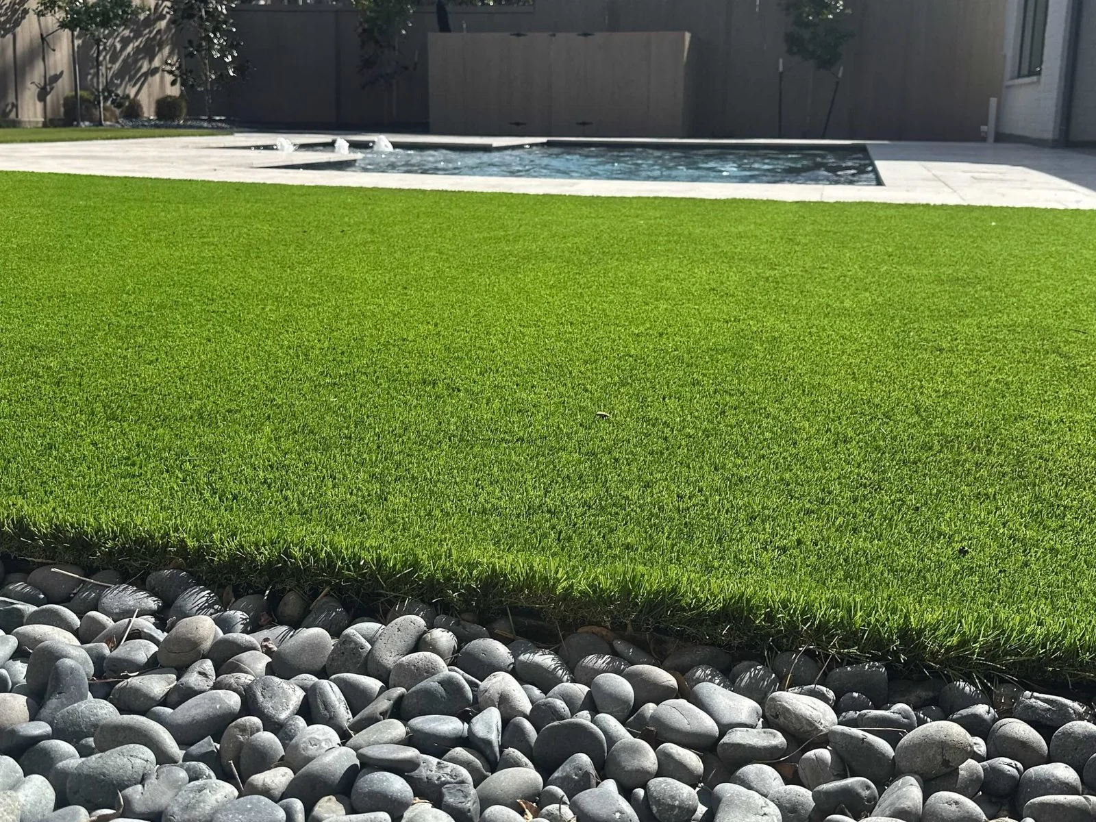 Artificial turf lawn with a river rock border